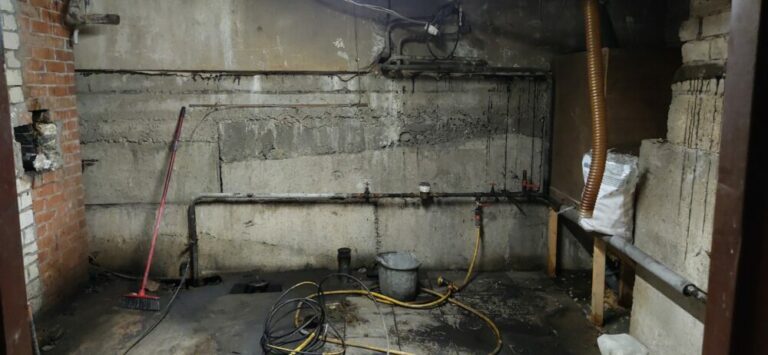 Basement renovation process. Dark dirty room with pipes