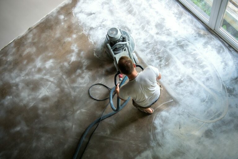 Builder workers working with concrete floor grinding machine, concrete floor repair