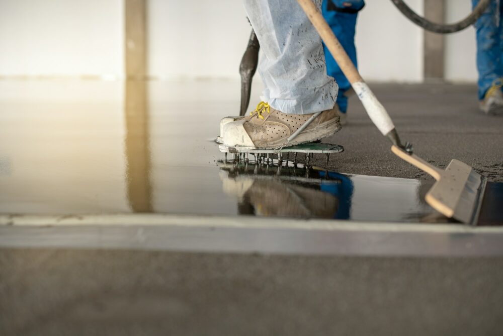 Worker working on the floor of an industrial building with special shoes to avoid damaging