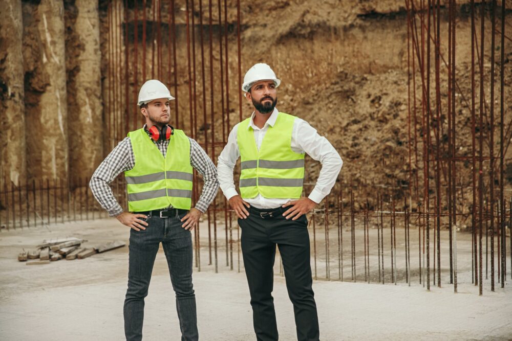 Serious builders standing on basement of new house